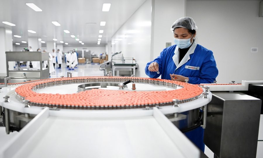 (FILES) This file photo taken on September 24, 2020 shows a staff member working during a media tour of a new factory built to produce a COVID-19 coronavirus vaccine at Sinovac, one of 11 Chinese companies approved to carry out clinical trials of potential coronavirus vaccines, in Beijing. - With the rollout of coronavirus vaccines beginning across the world, China has positioned itself as a key player, promising poorer nations priority access to its jabs. (Photo by WANG Zhao / AFP) / TO GO WITH China-vaccines-virus-health-diplomacy-politics,FOCUS by Helen ROXBURGH and Poornima WEERASEKARA