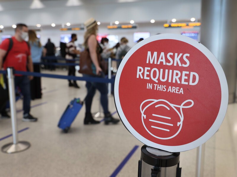 MIAMI, FLORIDA - FEBRUARY 01: A sign reading, 'masks required in this area,' is seen as travelers prepare to check-in for their Delta Airlines flight at the Miami International Airport on February 01, 2021 in Miami, Florida. An executive order signed by U.S. President Joe Biden last week mandates mask-wearing on federal property and on public transportation as part of his plan to combat the coronavirus (COVID-19) pandemic. (Photo by Joe Raedle/Getty Images)